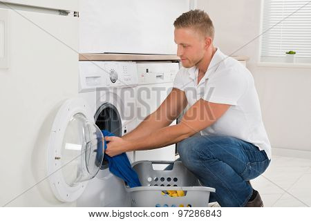 Man Loading Washing Machine With Clothes