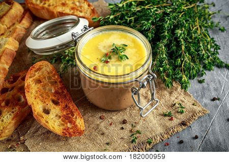 Home made chicken liver pate with thyme and ciabatta bread in jar.
