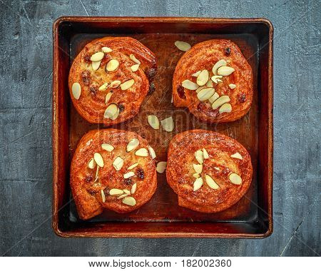 Freshly baked French raisin buns. Pains aux raisins on a vintage baking tray.