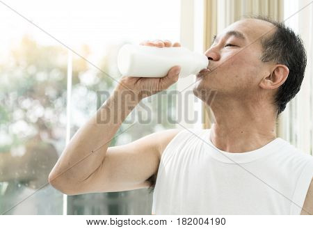 Close up Asian senior man drinking milk.