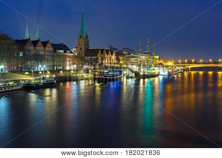Embankment of the Weser River and Protestant Lutheran Saint Martin Church in the old town of Bremen, Germany. Night panoramic view.