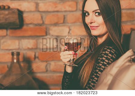 Woman Tasting Wine In Rural Cottage Interior