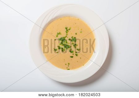 Creamy Vegetables Soup With Fresh Herbs In A White Bowl