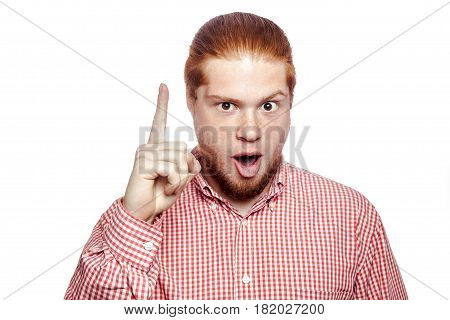 Excited man pointing a great idea happy bearded readhead businessman with red shirt and freckles looking at camera. studio shot isolated on white.
