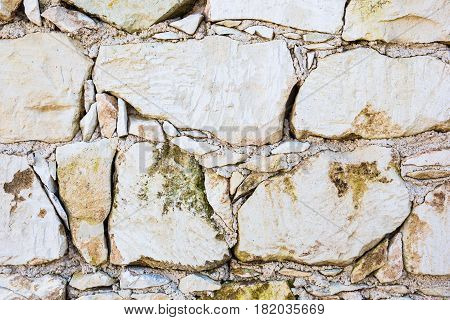 Background wall made of stone. Fragment of a wall from a chipped stone