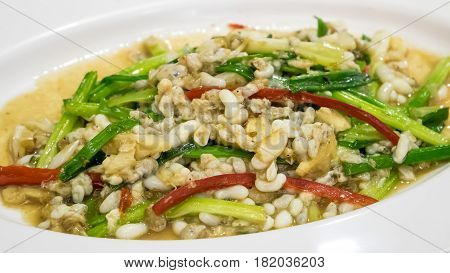 The delicious Thai stir-fried weaver ant egg (Kai Mod Pad Kai) on white plate.