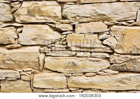Background wall made of stone. Fragment of a wall from a chipped stone