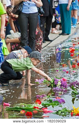 Volgograd Russia - May 9 2010: Boy laying flowers on a Lake of Tears on Mamaev Kurgan in Volgograd