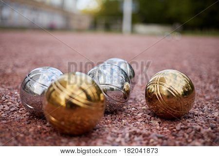 Group of petanque balls lying on ground, shallow dof.