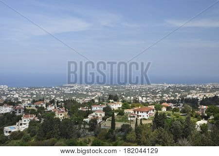 View to the North West over the Kyrenia town on the North of Cyprus with the Mediterranean sea and a blue sky in background .