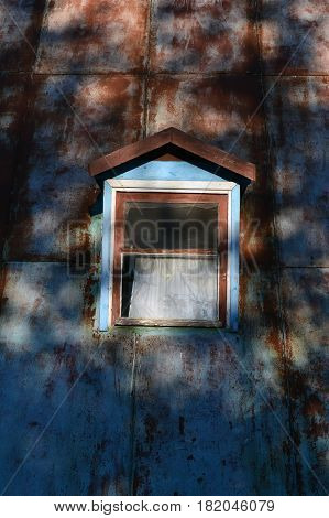 A small window in a rusty metal wall