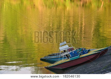 Two old catamarans on the shore of the lake