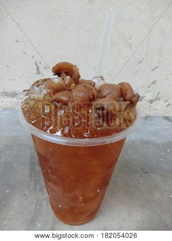 Summer drink fresh Longan syrup drink in glass focus-on-foreground with blur wall background sweet juice Thai friut drink