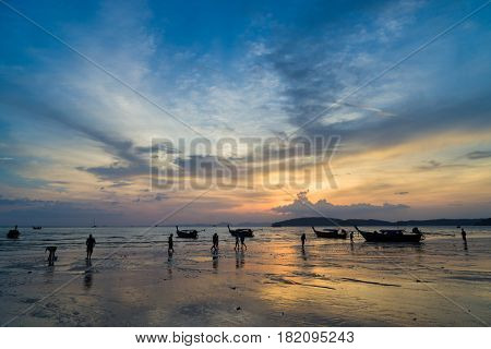 People on the Ao Nang beach at sunset in Krabi province Thailand