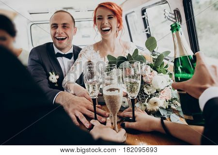 Stylish Happy Bride And Groom Toasting With Glasses Of Champagne And Having Fun With Bridesmaids And