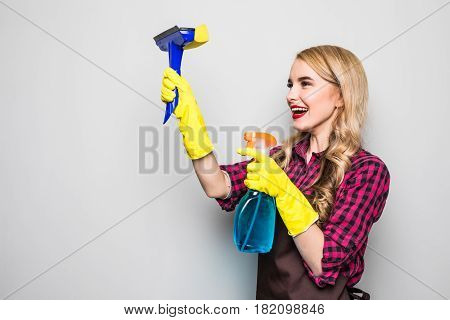 Portrait Of Attractive Young Woman Cleaning Windows Isolated On Grey