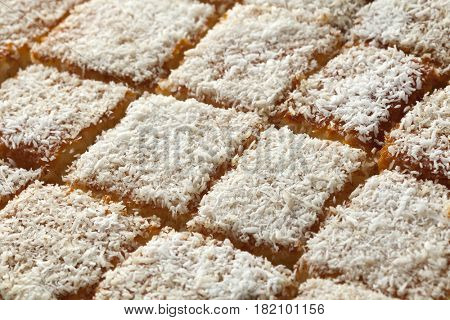  Fresh baked Moroccan yogurt cake cut into pieces decorated with white cocos full frame