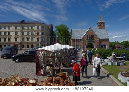 VYBORG, LENINGRAD OBLAST, RUSSIA - JUNE 6, 2015: People at the market square. The market building was erected in 1904-1904 by design of Karl Segerstad