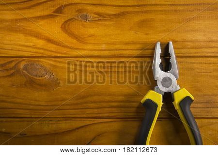 Close up of a multitool pliers on wooden background