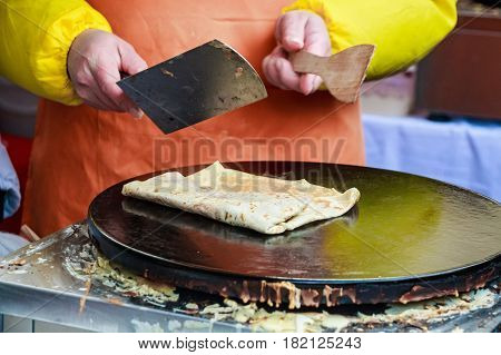 Close up of making crepe with jam outdoors on skillet