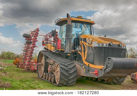 a large yellow tractor processes the field