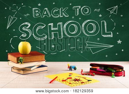Back to school concepty with writing on blackboard and desk, apple, books, items