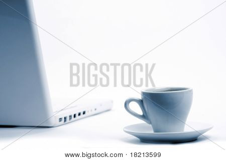 Taza de negro caliente humeante café en un ordenador portátil