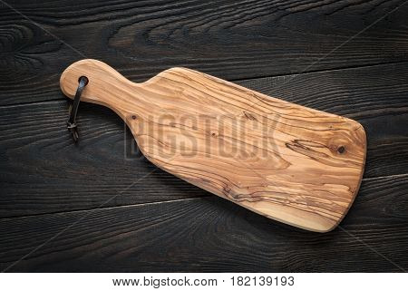 Food background. Olive Cutting board on dark wooden table. Copy space.