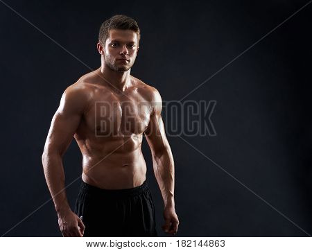Young strong athletic handsome man posing on black background copyspace shirtless male sportsman showing off his ripped fit and toned sexy body cropped studio shot fitness sport motivation concept.