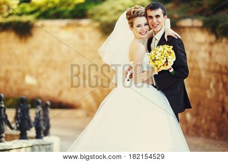 Merry Wedding Couple Stads On The Stone Backyard
