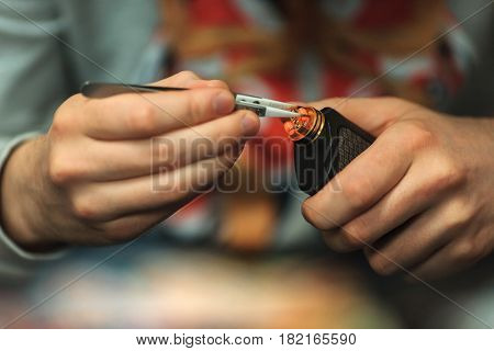Vape After-sales Service Of The E-cigarette. Male Hands Regulate Electronic Cigarette Coils With Pin