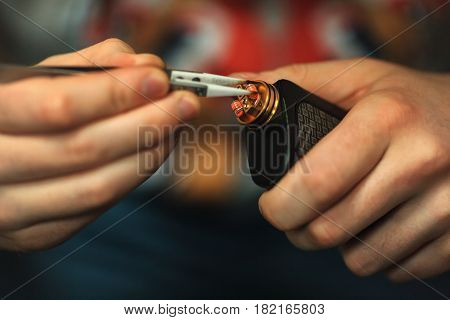 Vape After-sales Service Of The E-cigarette. Male Hands Regulate Electronic Cigarette Coils With Pin