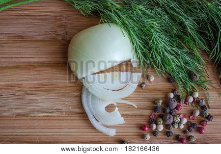 Spices on a wooden board, pepper, dill, wooden background
