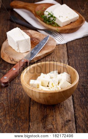 Sliced fresh brined white cheese from cow milk on wooden table