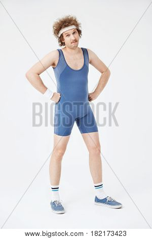Full length shot of sporty man in retro clothing posing with handson his hips