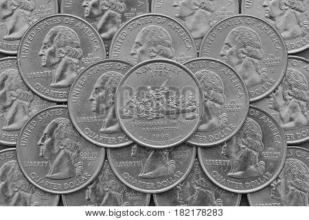 New Jersey State and coins of USA. Pile of the US quarter coins with George Washington and on the top a quarter of New Jersey State.