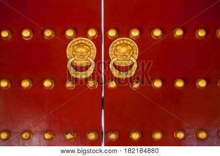 Ancient chinese gate red doors with golden rivets and dragon heads knockers adorned traditional ornaments