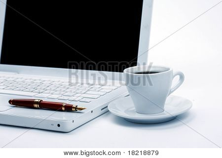Taza de negro caliente humeante café en un ordenador portátil