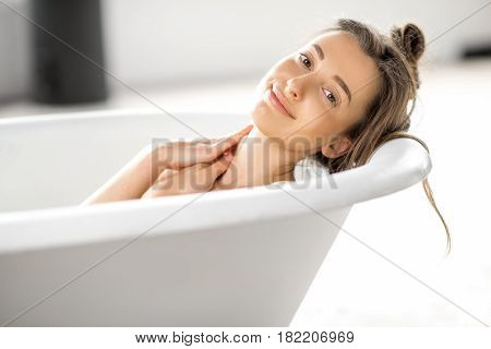 Close-up portrait of a young woman relaxing in the bathtube