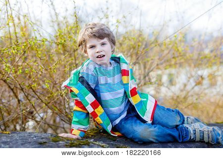 Outdoor fashion portrait of adorable little kid boy wearing colorful clothes. Spring fashion for boys and children.
