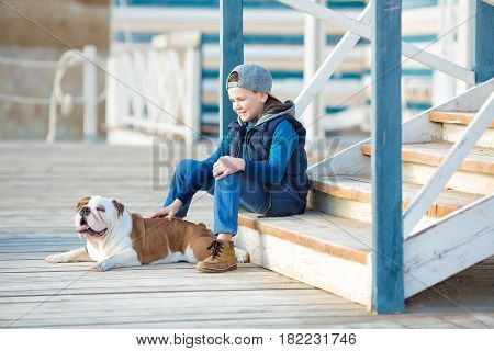Nice looking handsome boy on beach with english bulldog