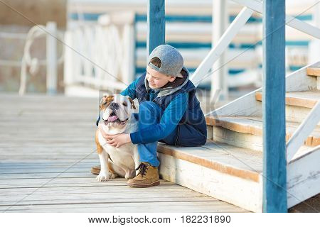 Nice looking handsome boy on beach with english bulldog