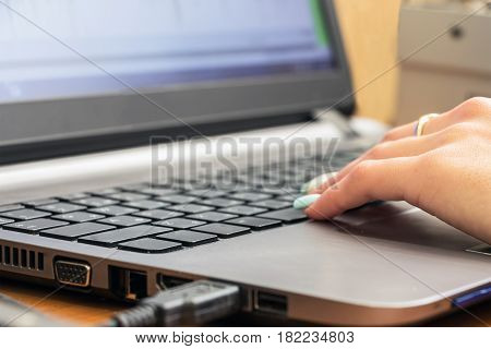 Part of the female hand on laptop keyboard. Selective focus