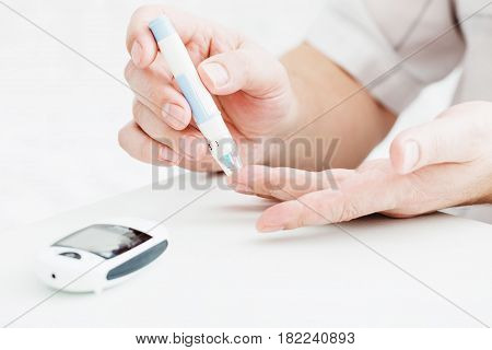 medicine diabetes glycemia health care and people concept - close up of male finger with test stripe