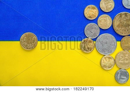 Ukrainian national coins and ten euro cents against the background of the national flag. Eurovision currency