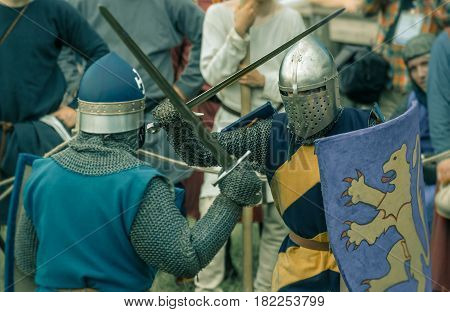 RITTER WEG MOROZOVO APRIL 2017: Festival of the European Middle Ages. Medieval joust knights in helmets and chain mail battle on swords with shields in their hands.