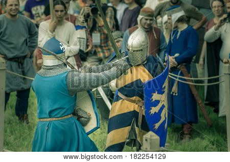 RITTER WEG MOROZOVO APRIL 2017: Festival of the European Middle Ages. Medieval joust knights in helmets and chain mail battle on swords with shields in their hands.