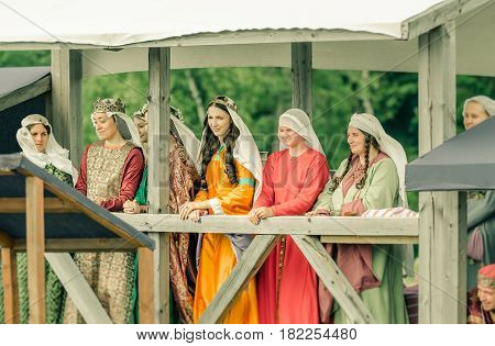 RITTER WEG MOROZOVO APRIL 2017: Ladies in medieval clothes stand in bed watching the tournament of Knights. Historical reconstruction.