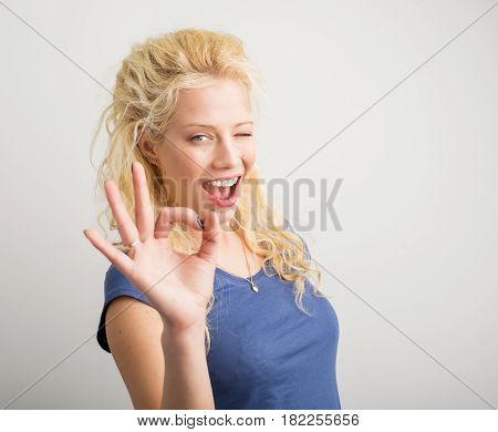 Woman winking and showing ok sign with her hand