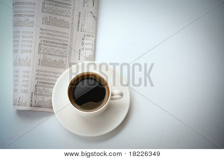 šálek kávy na noviny